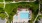 a swimming pool in a courtyard with lounge chairs